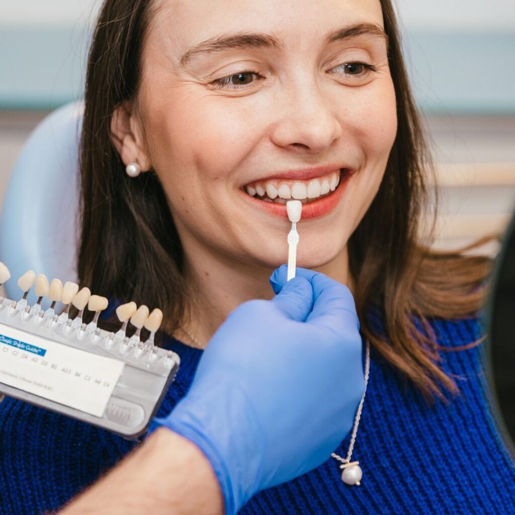 Dentist showing patient different shade options for teeth whitening