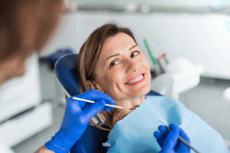 Patient smiling in dental chair at The Town House Dental Practice having a routine dental exam by dentist.
