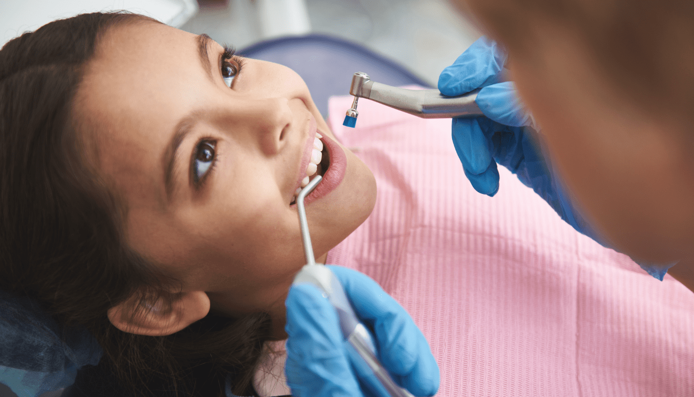 Young girl having her teeth cleaned by Dentist.